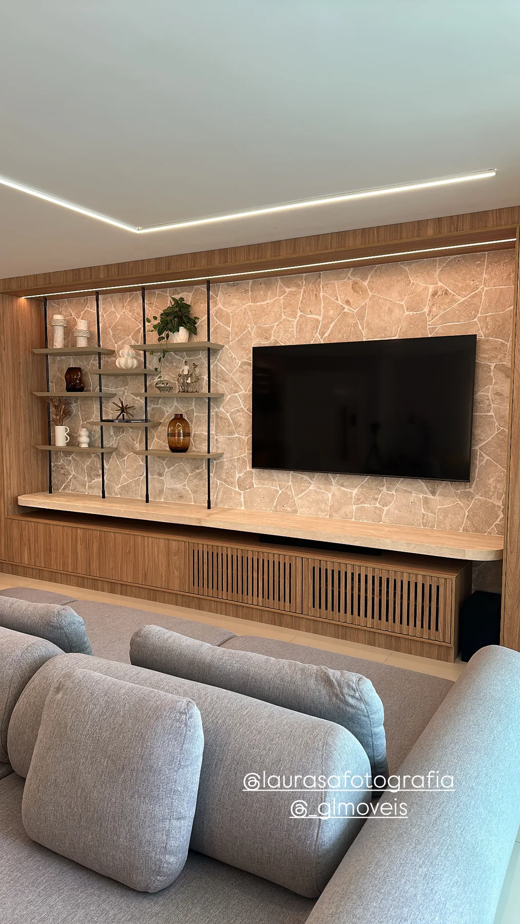 Painel de TV, marcenaria e pedra iluminada em ambiente residencial