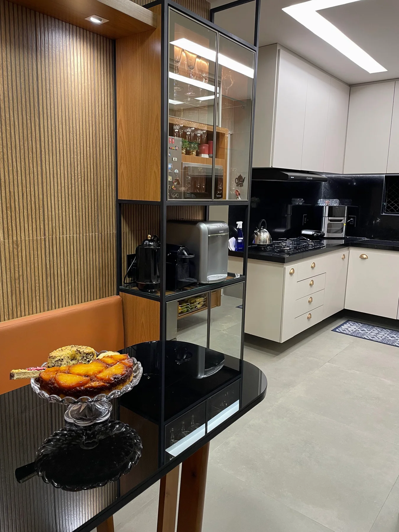 Cozinha com marcenaria ripada, armários claros e bancada escura